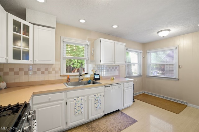 kitchen with decorative backsplash, white dishwasher, sink, light hardwood / wood-style flooring, and white cabinets