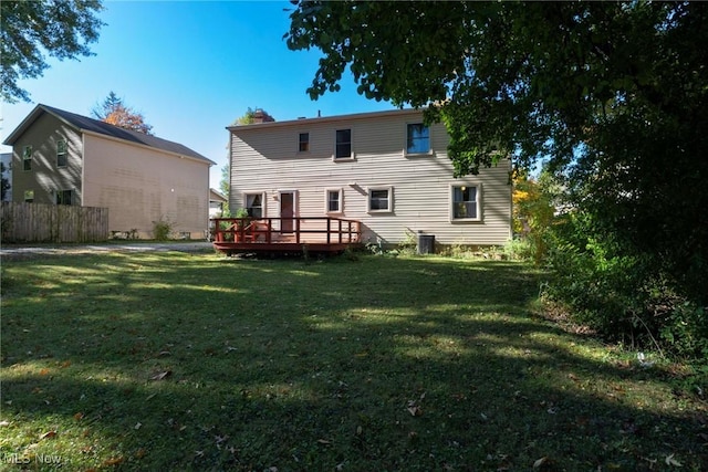 rear view of property with a yard, a deck, and cooling unit