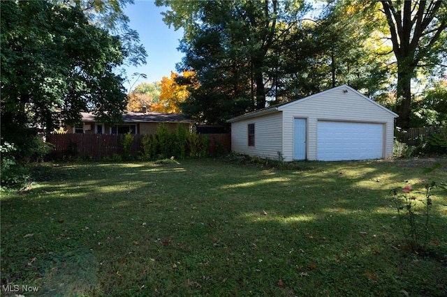 view of yard featuring a garage and an outbuilding