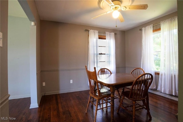 dining area with ceiling fan and dark wood-type flooring