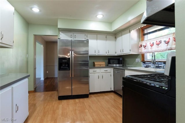 kitchen featuring white cabinets, appliances with stainless steel finishes, and light hardwood / wood-style flooring