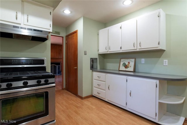 kitchen with light hardwood / wood-style flooring, white cabinetry, and stainless steel gas range