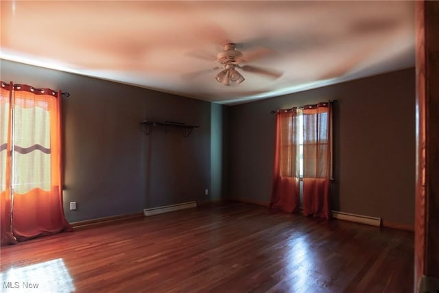 empty room featuring ceiling fan, dark hardwood / wood-style flooring, and baseboard heating