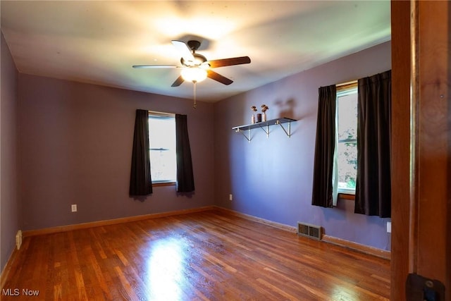 unfurnished room featuring hardwood / wood-style flooring, ceiling fan, and a healthy amount of sunlight