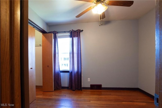 spare room featuring ceiling fan and dark hardwood / wood-style flooring