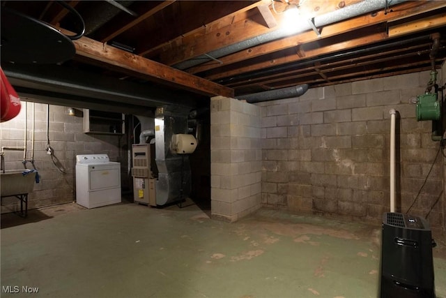 basement with washer / dryer, sink, and heating unit