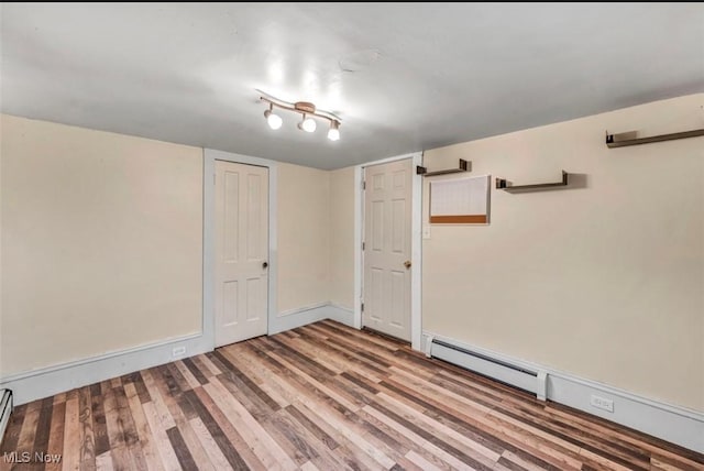 spare room featuring hardwood / wood-style flooring and a baseboard radiator