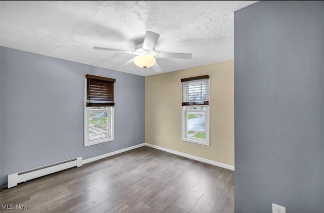 spare room featuring hardwood / wood-style floors, ceiling fan, a textured ceiling, and a baseboard radiator