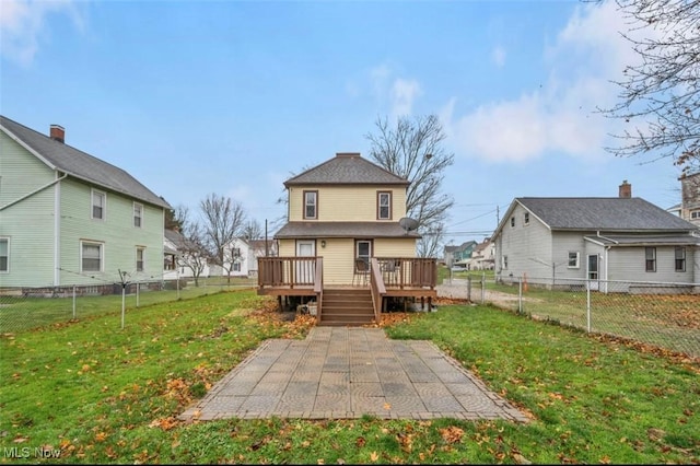 rear view of house with a lawn, a patio area, and a deck