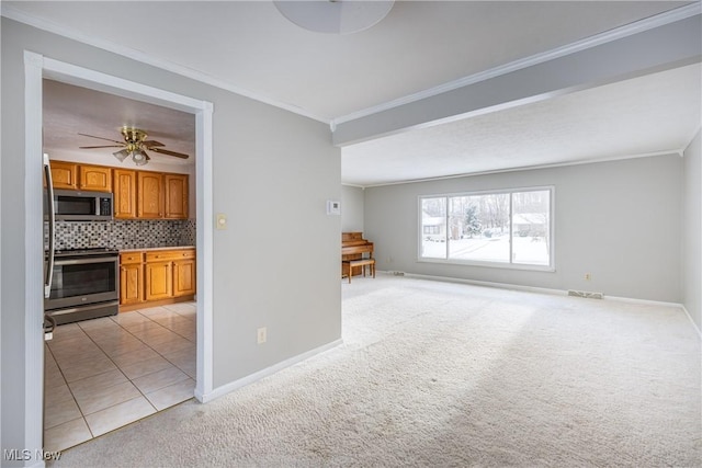 unfurnished living room featuring ceiling fan, light colored carpet, and ornamental molding