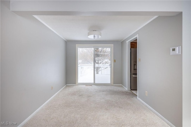 spare room featuring light colored carpet and ornamental molding