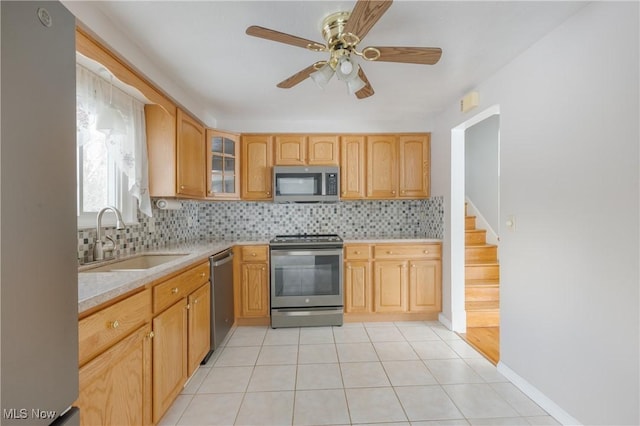 kitchen featuring backsplash, stainless steel appliances, ceiling fan, and sink