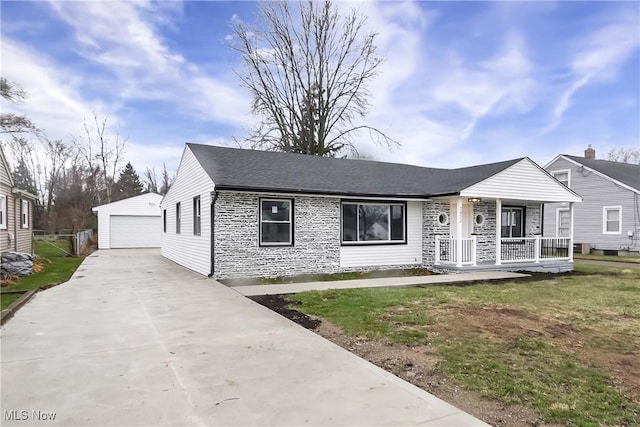 view of front of property featuring a front lawn, covered porch, an outdoor structure, and a garage