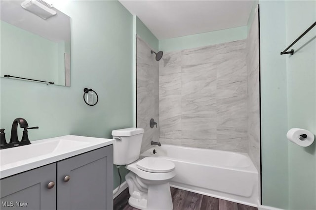 full bathroom featuring hardwood / wood-style floors, vanity, toilet, and tiled shower / bath combo