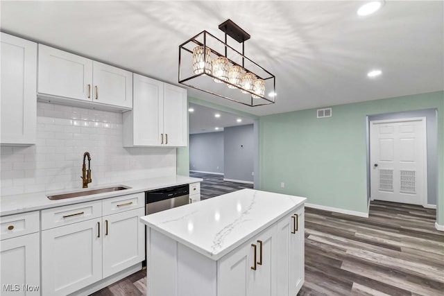 kitchen with dark hardwood / wood-style flooring, sink, pendant lighting, dishwasher, and white cabinetry