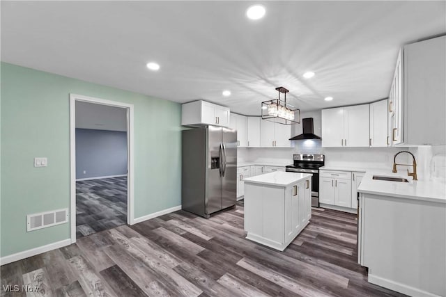 kitchen with a center island, white cabinets, wall chimney range hood, sink, and stainless steel appliances