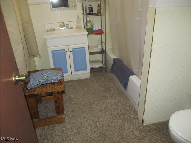 full bathroom with shower / bath combo, vanity, toilet, and tile walls