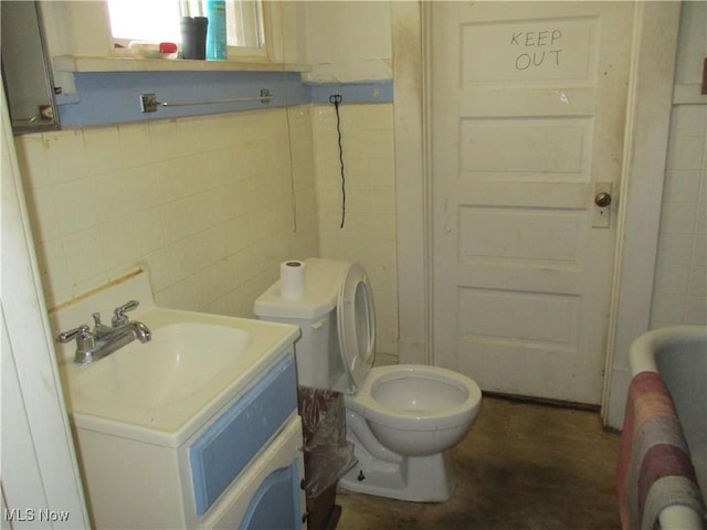 bathroom featuring vanity, toilet, and tile walls