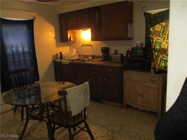 kitchen featuring dark brown cabinetry and sink