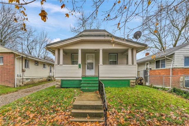 bungalow-style home featuring covered porch and a front yard