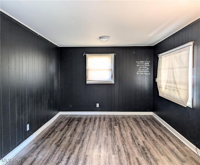 empty room featuring hardwood / wood-style flooring and wood walls