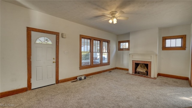 unfurnished living room with a fireplace, a textured ceiling, light colored carpet, and ceiling fan