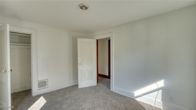 unfurnished bedroom featuring light carpet and a closet