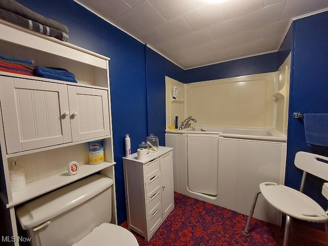 bathroom with a washtub, sink, and toilet