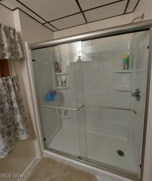 bathroom with a drop ceiling and walk in shower