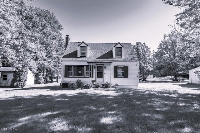 cape cod-style house featuring a lawn and cooling unit