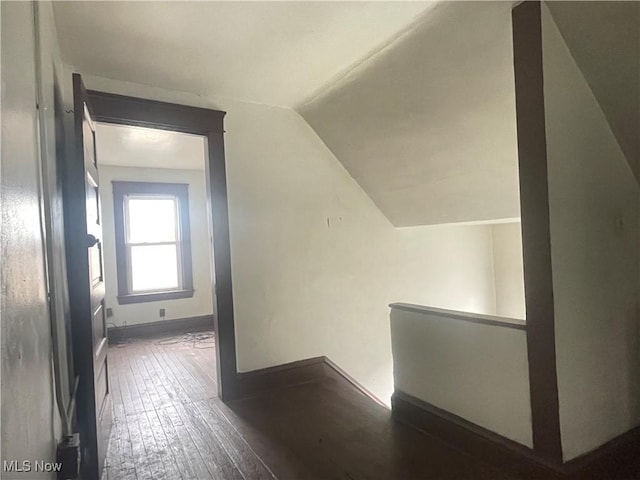 hall featuring dark hardwood / wood-style flooring and vaulted ceiling