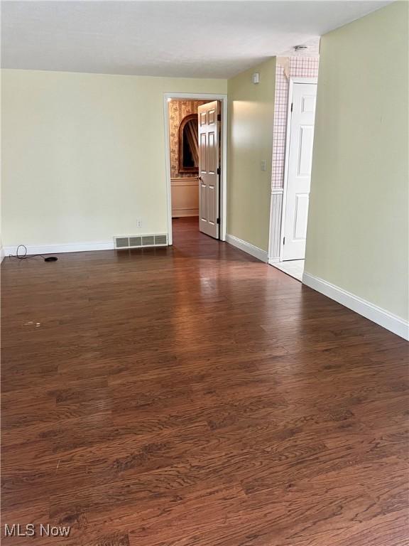 spare room featuring dark wood-type flooring