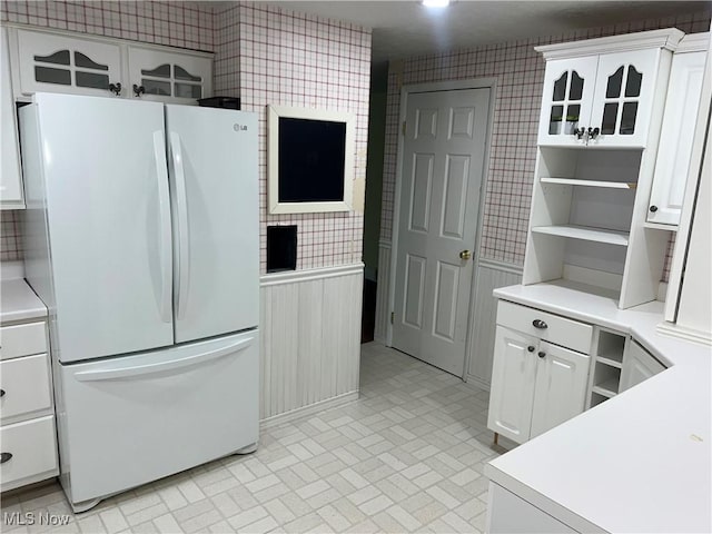 kitchen with white refrigerator and white cabinetry