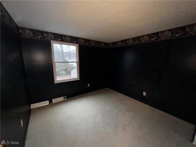 spare room featuring carpet and a textured ceiling