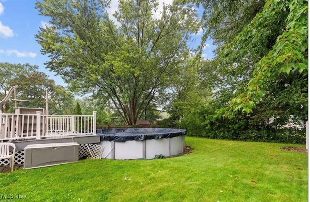 view of yard with a swimming pool side deck