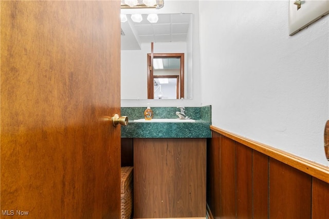 bathroom featuring vanity and wood walls