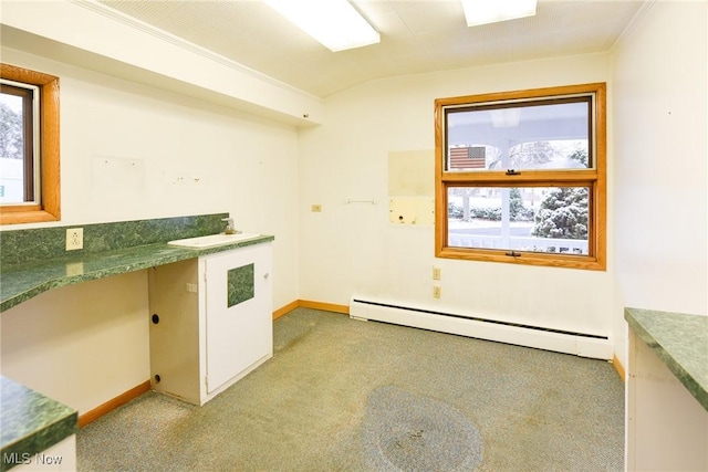 kitchen with built in desk, light colored carpet, and a baseboard heating unit