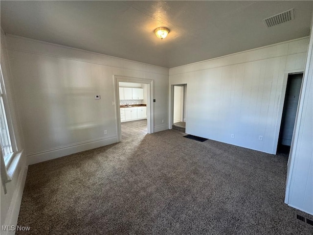 empty room with dark carpet and a wealth of natural light