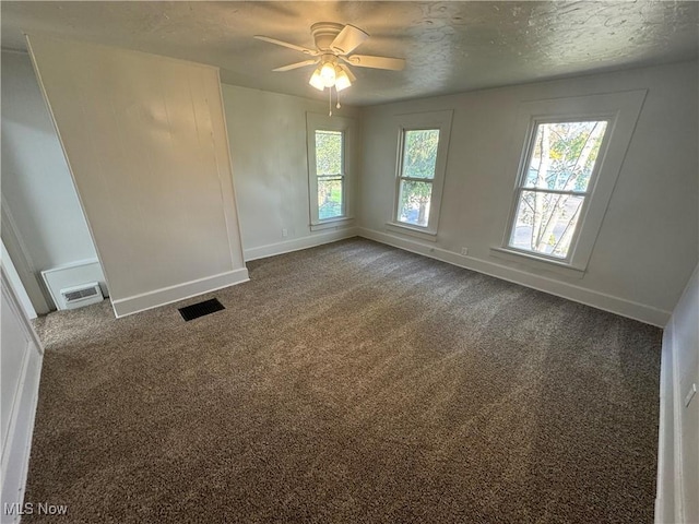 spare room featuring carpet flooring, ceiling fan, and a textured ceiling