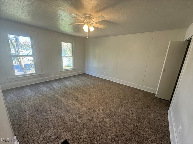 carpeted empty room with ceiling fan and a textured ceiling