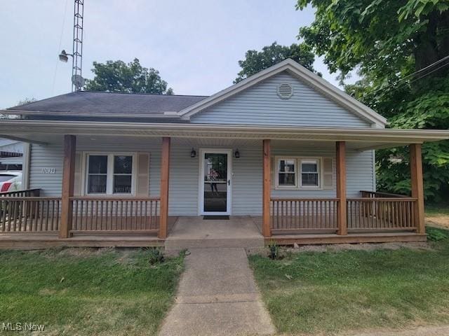 bungalow-style home with a front lawn and a porch