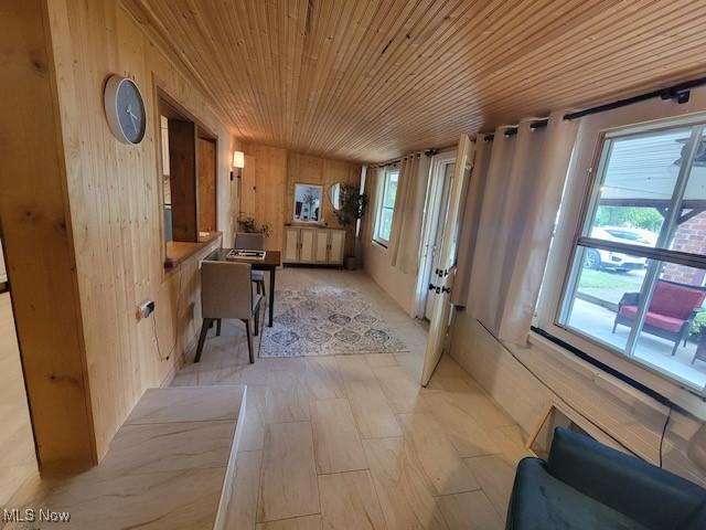 hallway featuring wood walls and wood ceiling