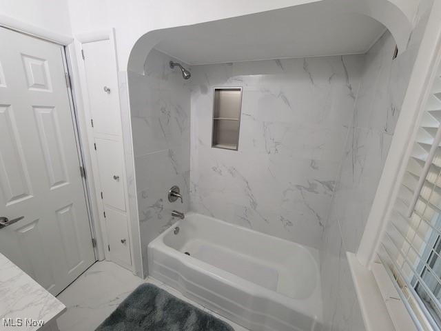 bathroom featuring vanity and tiled shower / bath