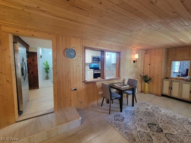 dining space featuring wood walls and wood ceiling