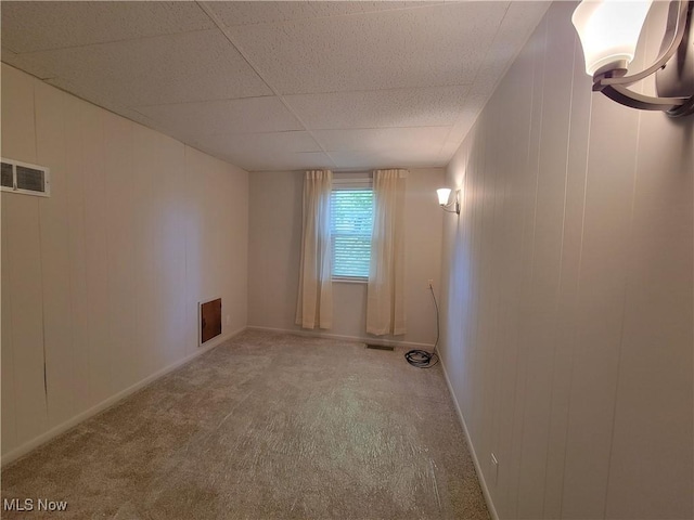 unfurnished room with carpet flooring and a paneled ceiling