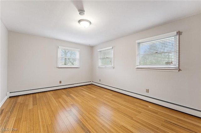 empty room featuring baseboard heating and light wood-type flooring