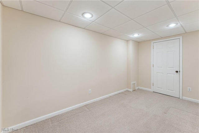 carpeted empty room with a paneled ceiling