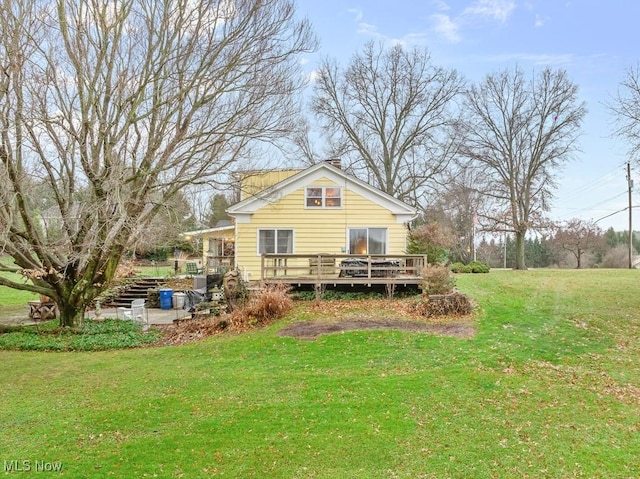 back of house featuring a deck and a yard