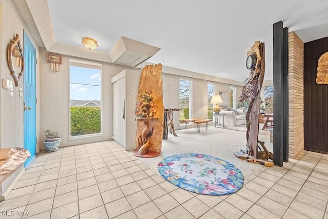 foyer featuring light tile patterned flooring and wooden walls