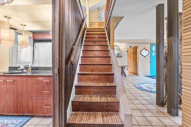 stairway featuring tile patterned floors and sink